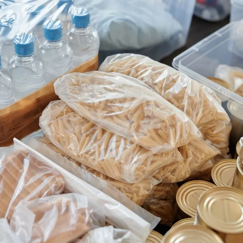 Caja de donación con pastas, latas y botellas de agua